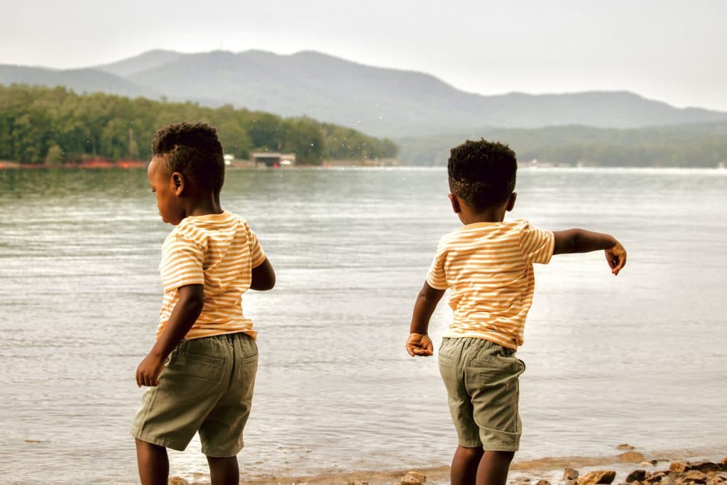 Kids throwing rocks at Morganton Beach during their Blue Ridge Family Vacation 