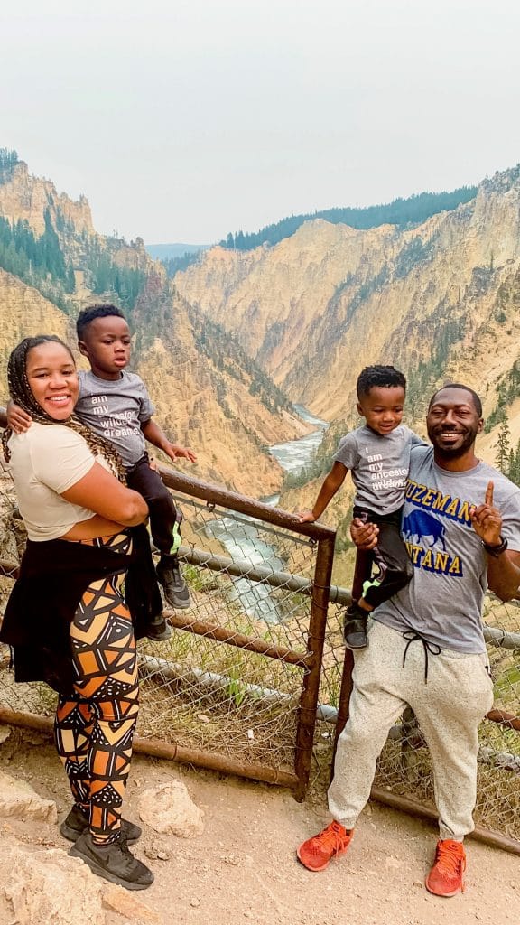 Family of four posing in front of the Grand Canyon of the Yellowstone National Park