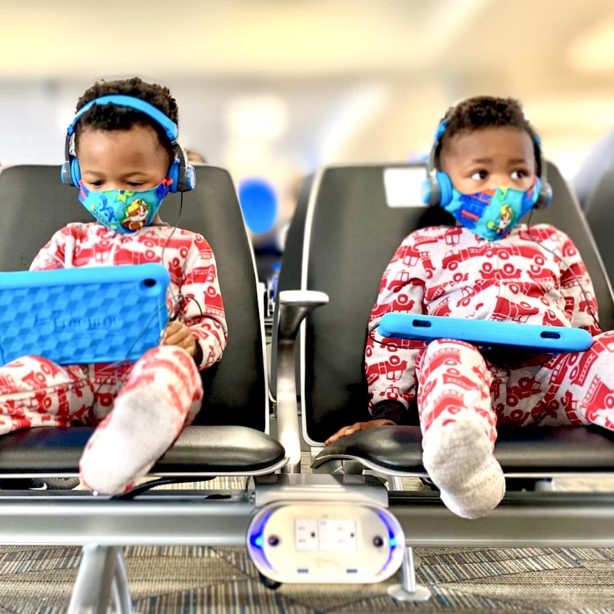 toddlers dressed in PJs ready to sleep on the plane