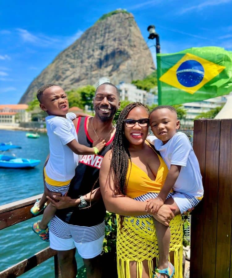 Family enjoying their Brazil itinerary in front of the flag and Sugarloaf Mountain 