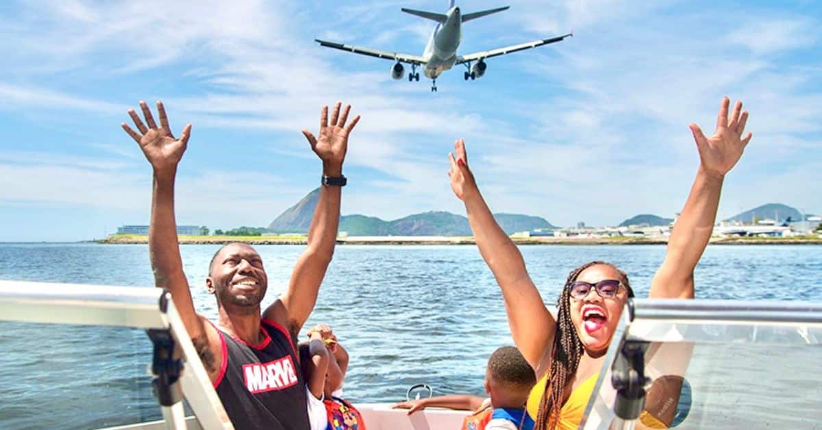 Family spending time in Brazil on Guanabara Bay in Rio with a plane landing at the airport in the background