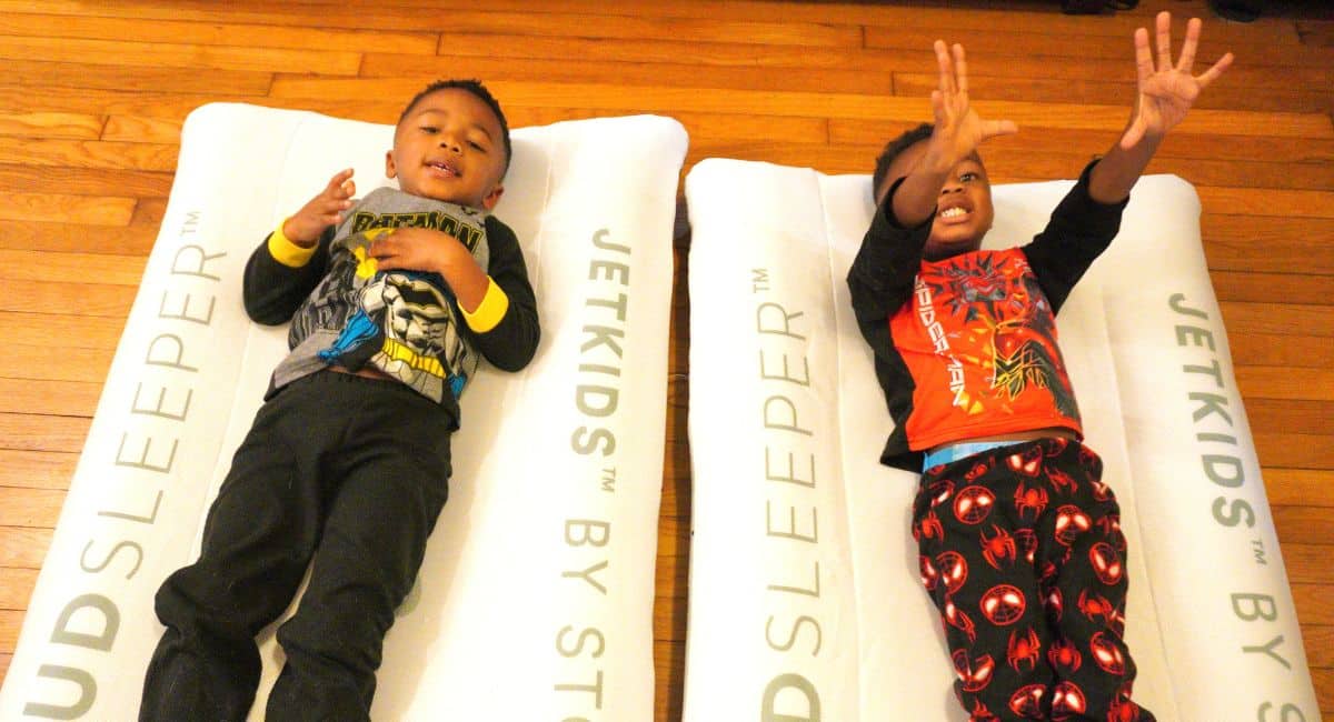 Twin toddlers laying on their toddler travel beds