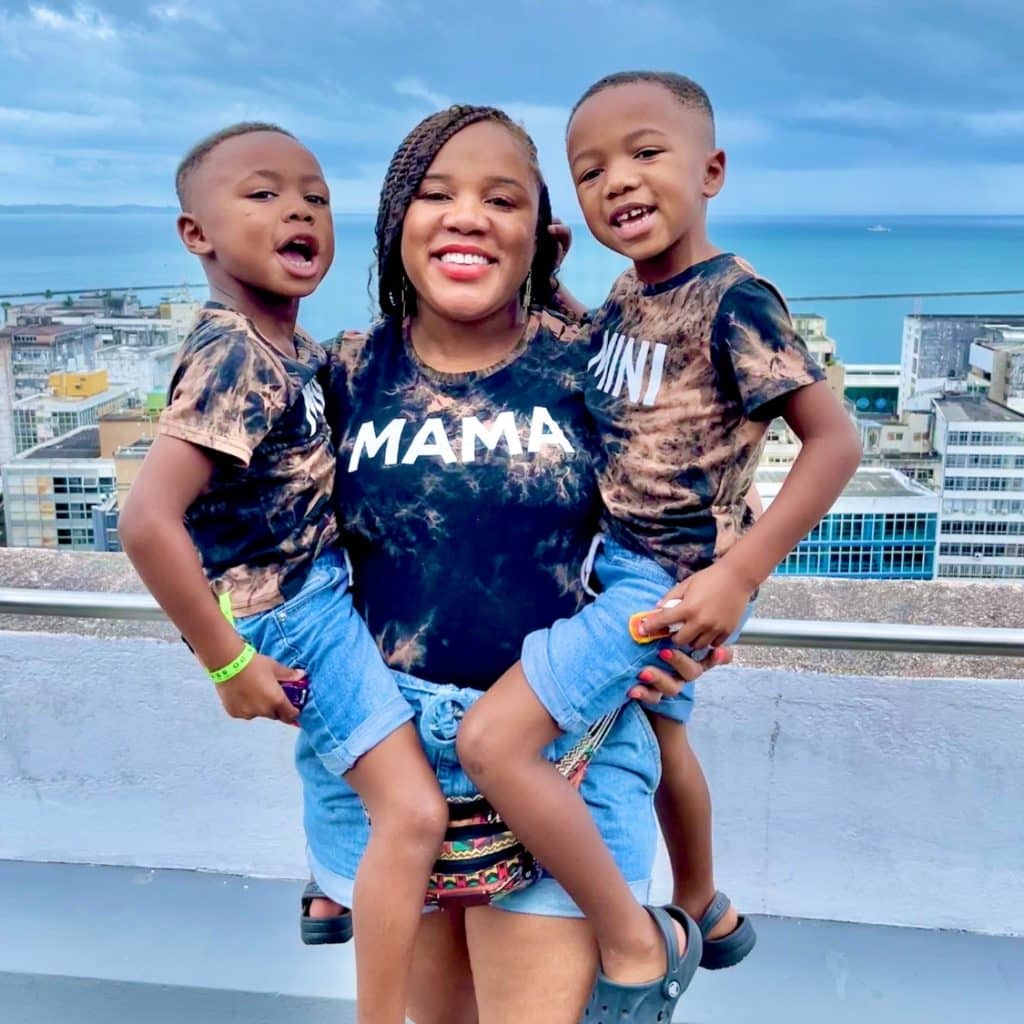 Mom and twin boys posing for a picture with the view of Salvador, Bahia in Northeast Brazil in the background