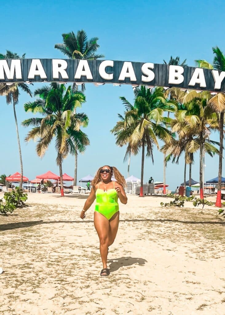 Running in front of the Maracas Bay sign on the beach