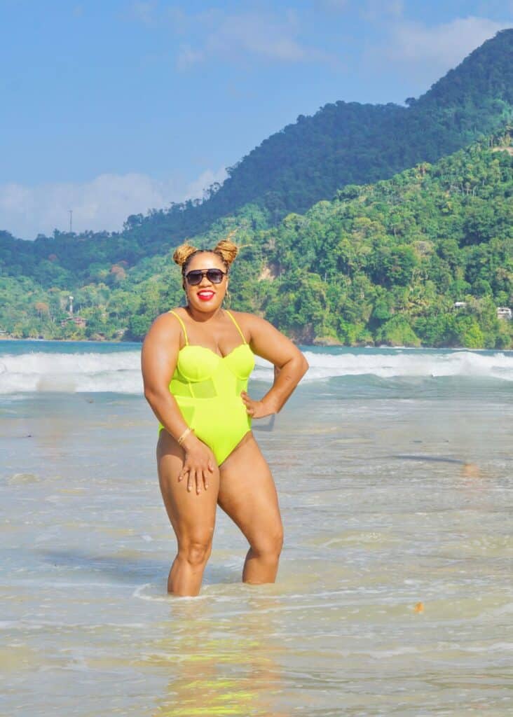 Posing in front of the beautiful shoreline of Maracas Bay Beach with a lime green one-piece swimsuit. 