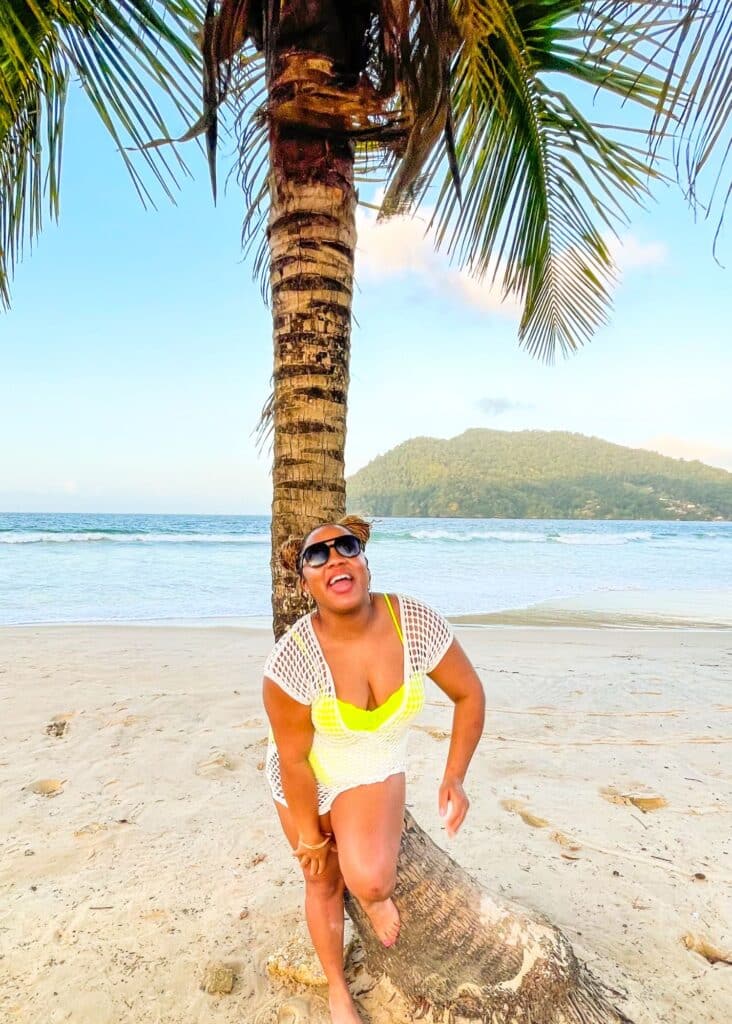 Posing in front of a palm tree on Maracas Bay Beach, a hidden gem of Trinidad.