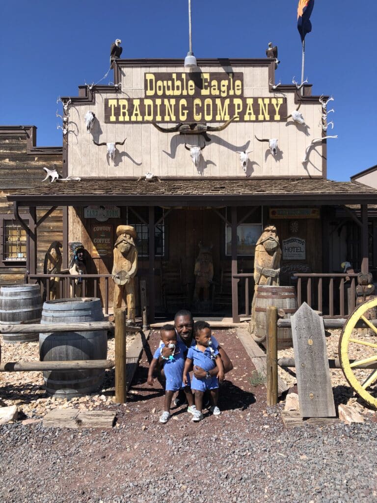 My husband and twin boys posing in front of the Double Eagle Trading Company a tourist stop on the day trip from Sedona to Grand Canyon.