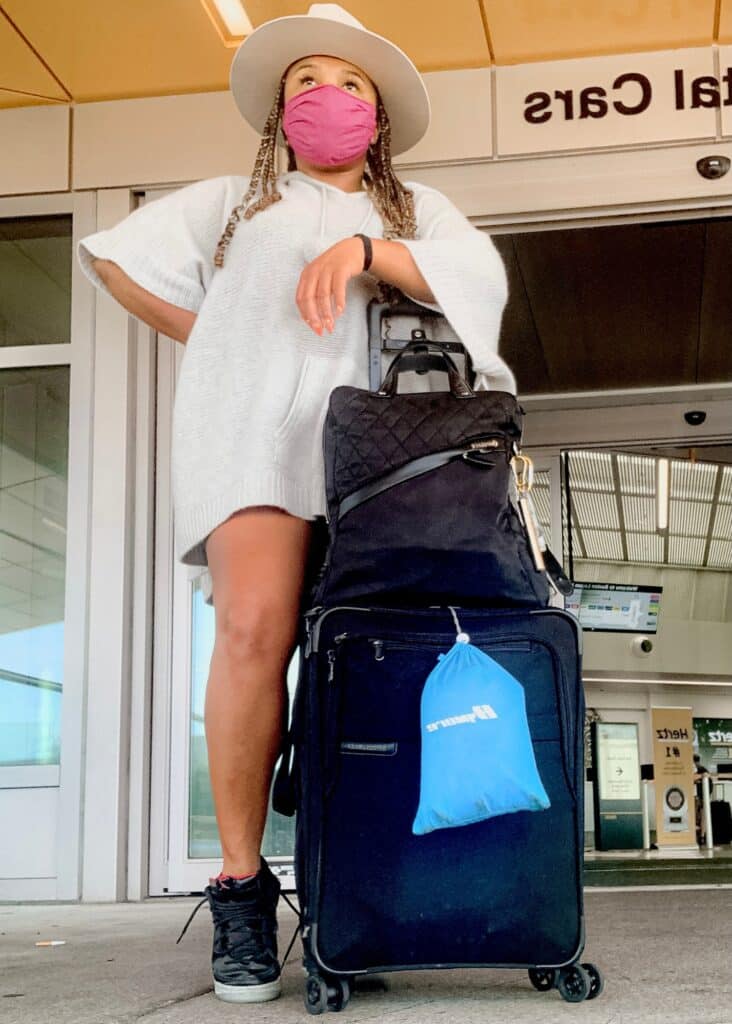 The key to the perfect minimalist packing list is the perfect carry on. Here I am with my favorite carry on in front of the departures terminal. 