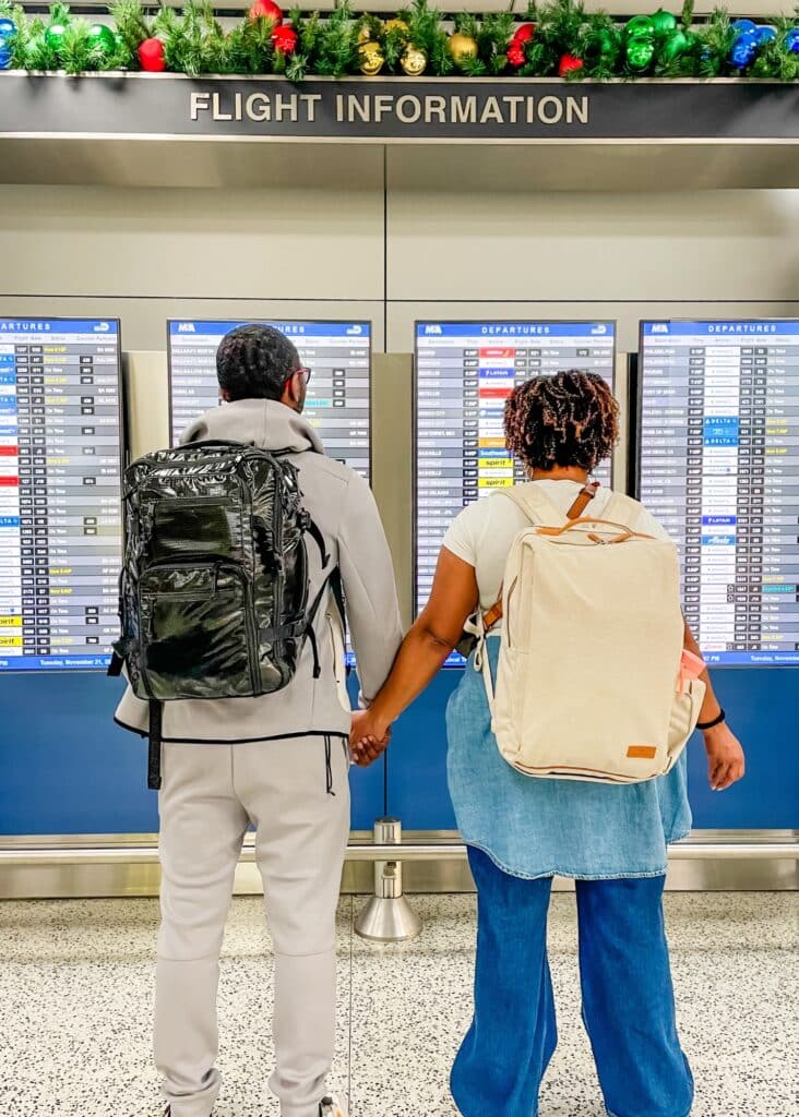 My husband and I at the airport wearing our favorite travel backpacks. 