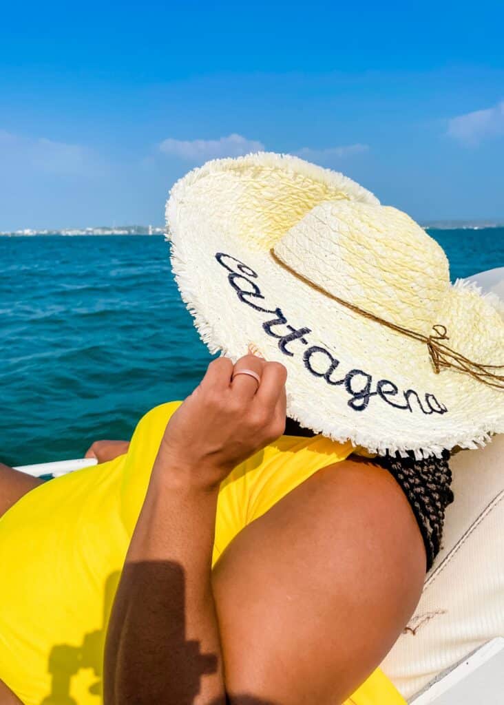 Me on the bow of a boat in my bright yellow swimsuit and my "Cartagena" hat.