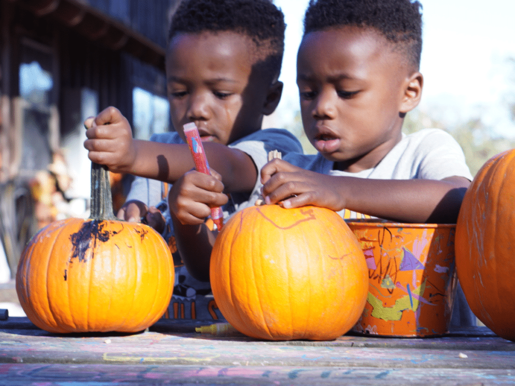 The boys drawing on pumpkins at Mrs. Heather's Farm in NOLA.